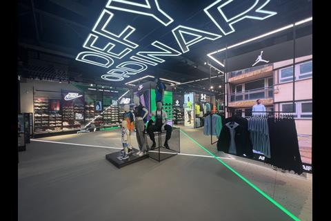 Interior of Footasylum store, Lakeside Shopping Centre, showing product on display and the words 'Defy ordinary' on the ceiling